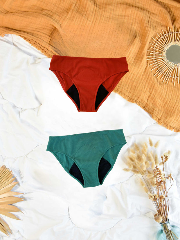 lot de  culottes à plat sur un lit de couleurs rouge et verte