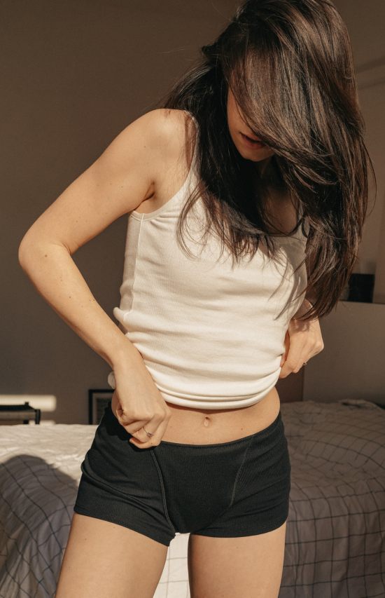 jeune femme dans sa chambre en boxer noir pendant ses règles